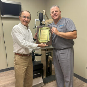 Dr. George Sehi presenting Dr. Hisham Arar with the Enrollment plaque